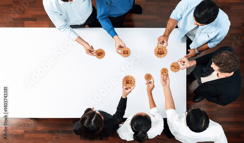 Foto A diverse group of professionals collaborates around a white table, engaging with gears to brainstorm innovative solutions and enhance teamwork in a creative environment