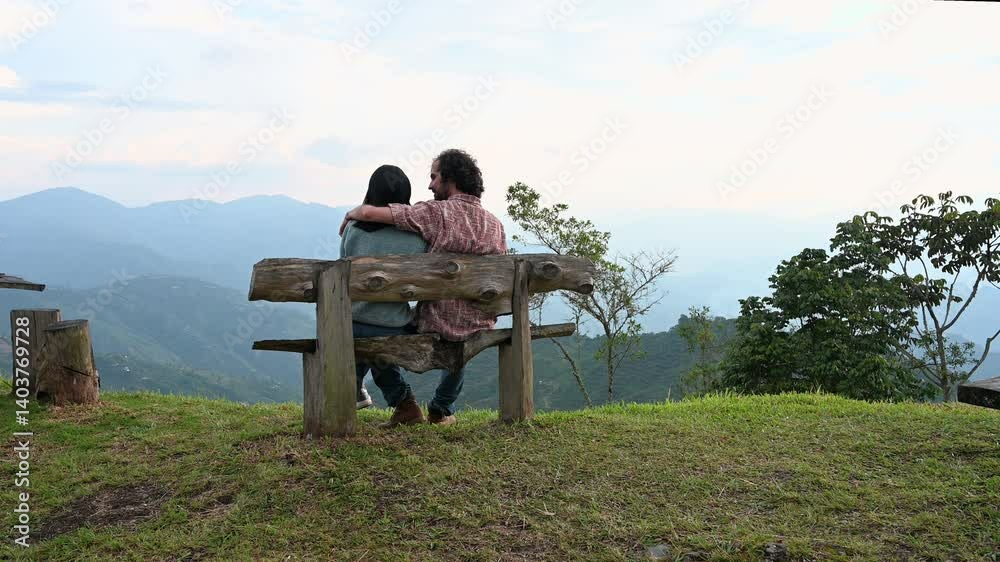 Couple enjoying mountain view from wooden bench