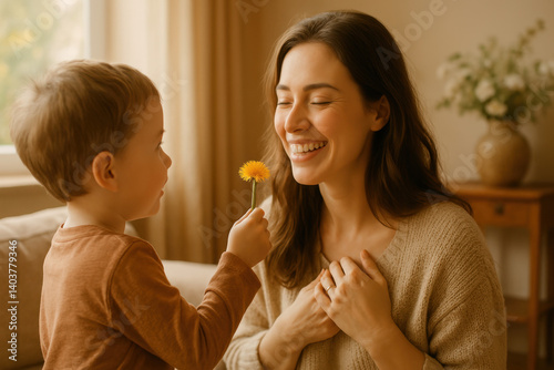 Petit garçon offrant une fleur à sa maman pour la fête des mères, scène douce et lumineuse dans un salon cosy, complicité familiale et tendresse partagée.