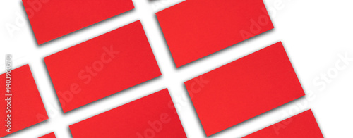 Mockup of horizontal red business cards stacks arranged in rows at white textured paper background. Banner.