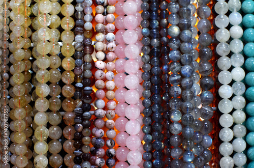 Strands of colorful natural agate and rose quartz beads, labradorite beads on the gemstone market.