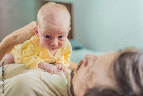 A newborn baby rests peacefully on the father's chest, feeling the warmth and heartbeat of his parent. A tender moment of bonding, love, and security, symbolizing the deep connection between father