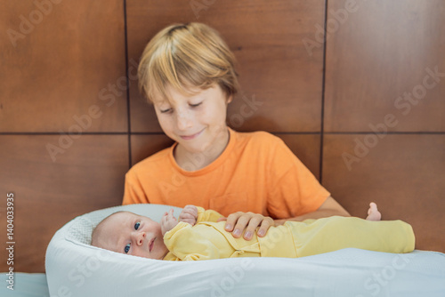 A young boy lovingly holds his newborn brother in a cozy sleep cocoon, sharing a tender sibling moment. A heartwarming scene of family bonding, protection, and the start of a lifelong brotherly