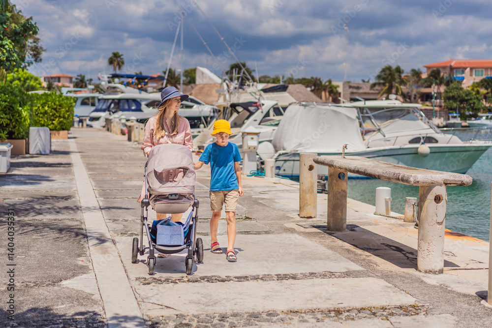 A mother and her elder son enjoy a peaceful walk along the waterfront, pushing a baby stroller with their youngest family member. A heartwarming moment of family bonding, parenting, and outdoor