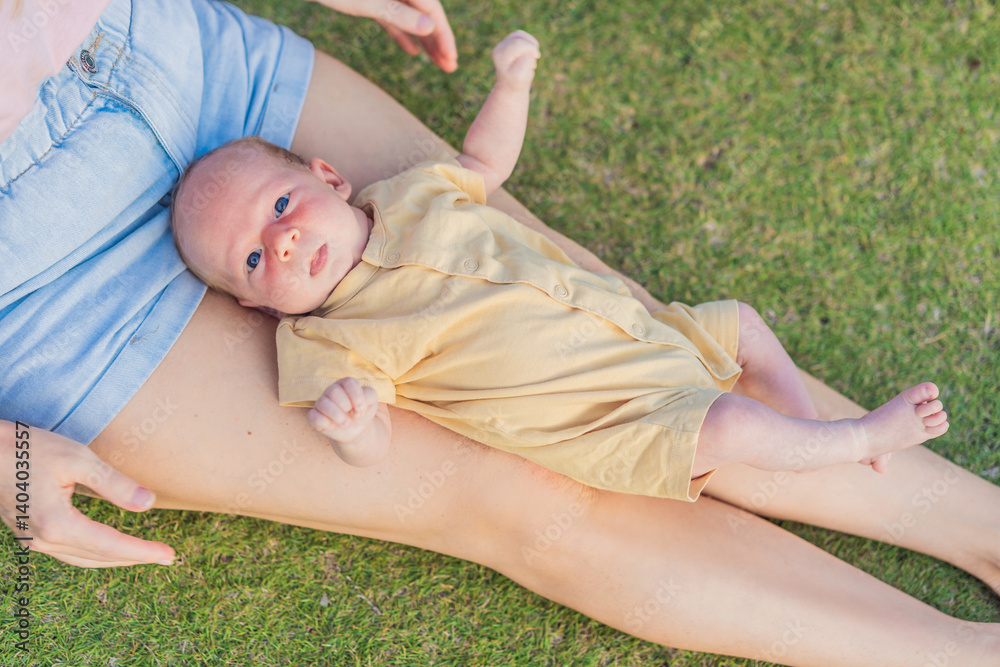 Young mother enjoying a peaceful walk in the park with her one-month-old baby. Motherhood, bonding, and outdoor family time concept