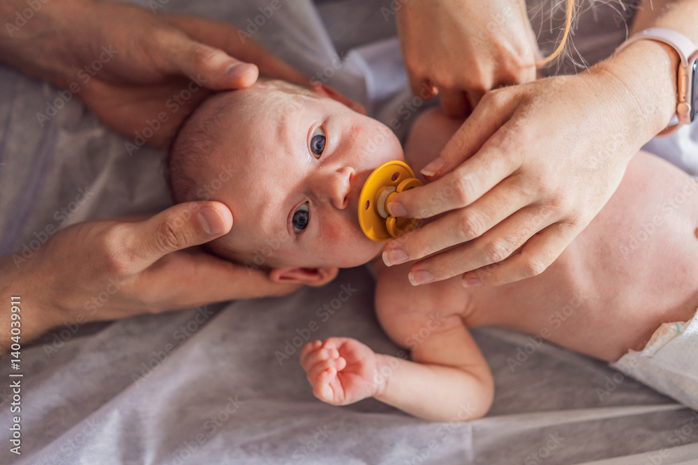 A newborn baby receives gentle osteopathic care, lying calmly while the specialist carefully examines and adjusts the infant. A moment of professional pediatric care, early development, and holistic
