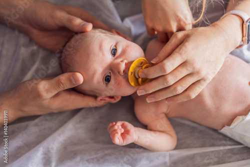 A newborn baby receives gentle osteopathic care, lying calmly while the specialist carefully examines and adjusts the infant. A moment of professional pediatric care, early development, and holistic