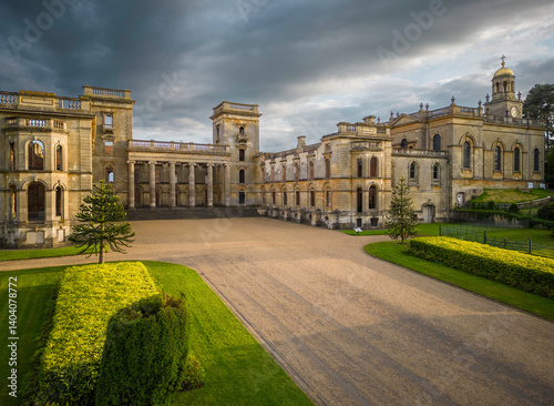 Grand Historic Palace Courtyard with Baroque Architecture and Formal Gardens under Dramatic Evening Sky