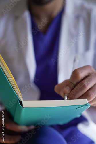 Doctor's Hands Writing Patient Notes in Medical Notebook, Focus on Clinical Documentation