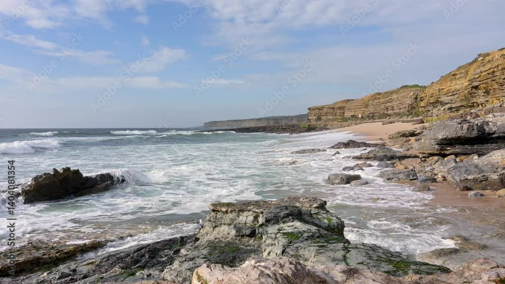 Waves crash against the rocky shoreline of Pedra Branca in Ericeira, Portugal, with layered cliffs and turquoise water. Waves crash against the rocky shoreline of Pedra Branca in Ericeira, Portugal, with layered cliffs and turquoise water.