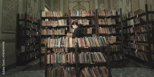 Librarian searching books in an old library