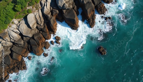 Aerial shot of South Africa scenic coastline. Drone view turquoise ocean waves crashing against rocky cliffs. Rugged coastal landscape, mix of nature, water, with high contrast between sea, land.