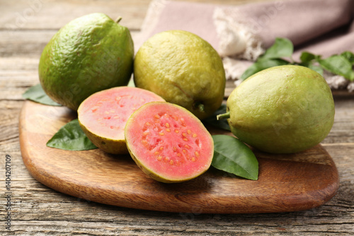 Fototapeta Naklejka Na Ścianę i Meble -  Fresh whole and cut guava fruits on wooden table, closeup