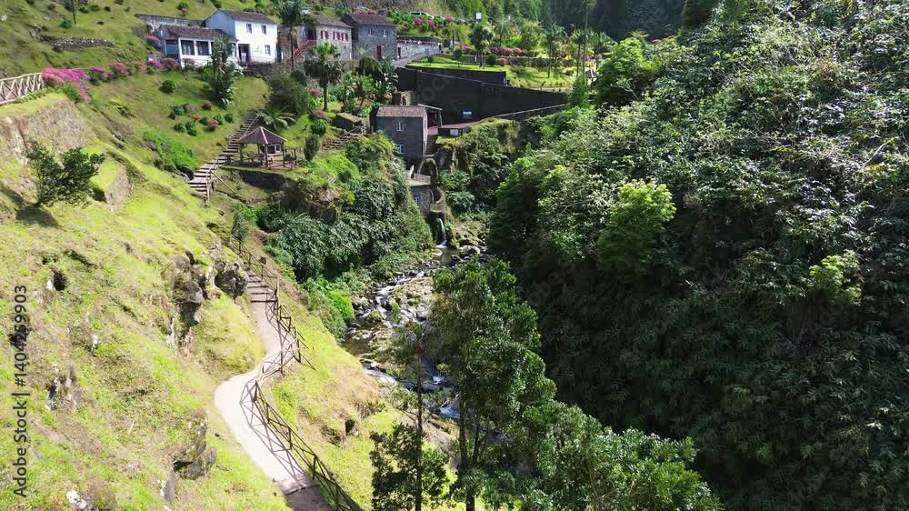 Aerial view of Parque Natural da Ribeira dos Caldeirões in São Miguel, Azores, showcasing historic water mills, lush vegetation, and a flowing stream in a beautifully preserved nature