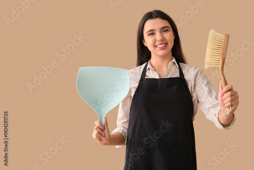 Young woman with dustpan an...