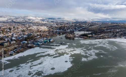Cuadro en lienzo Aerial view of a partially frozen lake Klamath Falls, Oregon, USA, with a marina and a town nestled against snow-covered mountains in the background