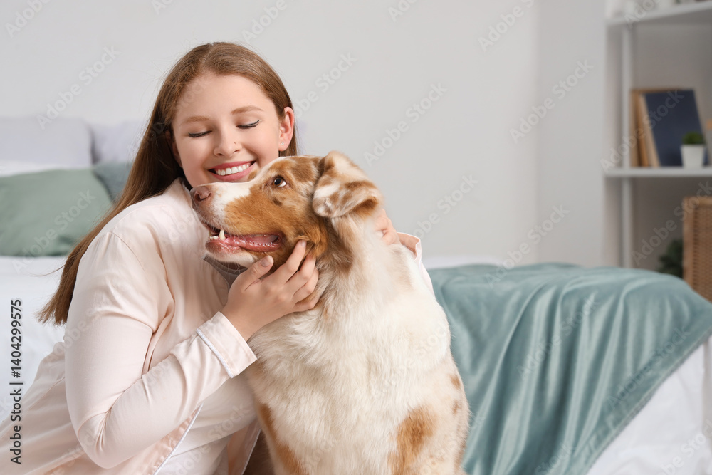 Young woman with cute Australian Shepherd dog at home