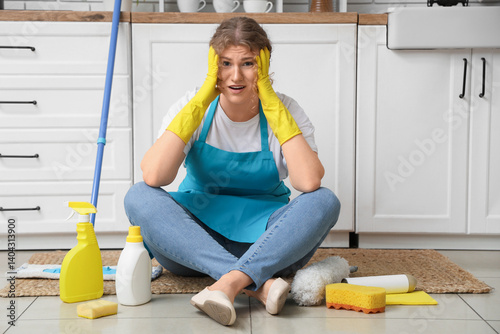 Stressed female janitor sit...