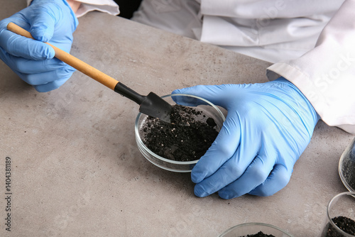 Scientist studying soil at ...