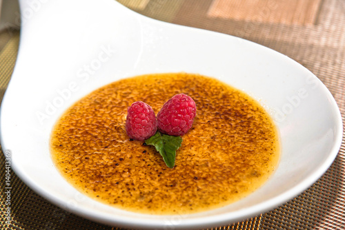 Obraz na plátně Crème brûlée, a caramel-crusted dessert with raspberry, red berries, and crème b