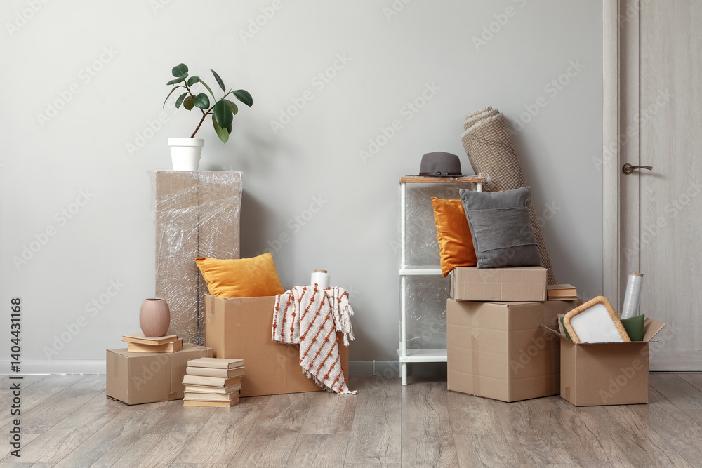 Cardboard boxes with stuff near light wall in room on moving day