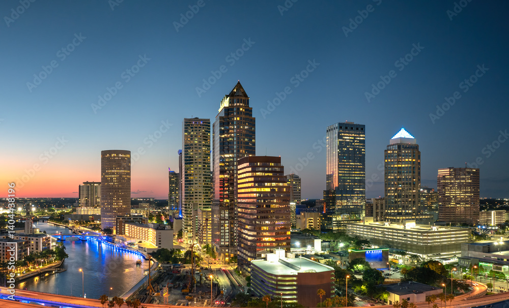 Fototapeta premium American city skyline with brightly illuminated high commercial buildings and streets. Night urban landscape of downtown district of Tampa in Florida, USA.