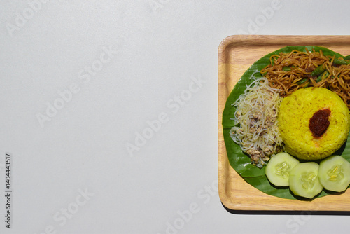 Nasi kuning or yellow rice or tumeric rice is a traditional Indonesian food, made from rice cooked with turmeric, coconut milk, and spices served with shredded fish, rice vermicelli, fried noodles.