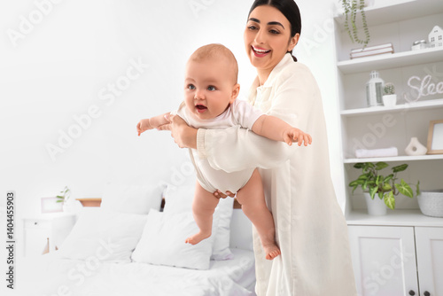 Happy mother holding her li...