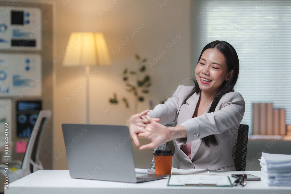 Young happy asia business woman relaxing stretching her arms after working on a laptop computer in office at night, office syndrome concept Young happy asia business woman relaxing stretching her arms after working on a laptop computer in office at night, office syndrome concept