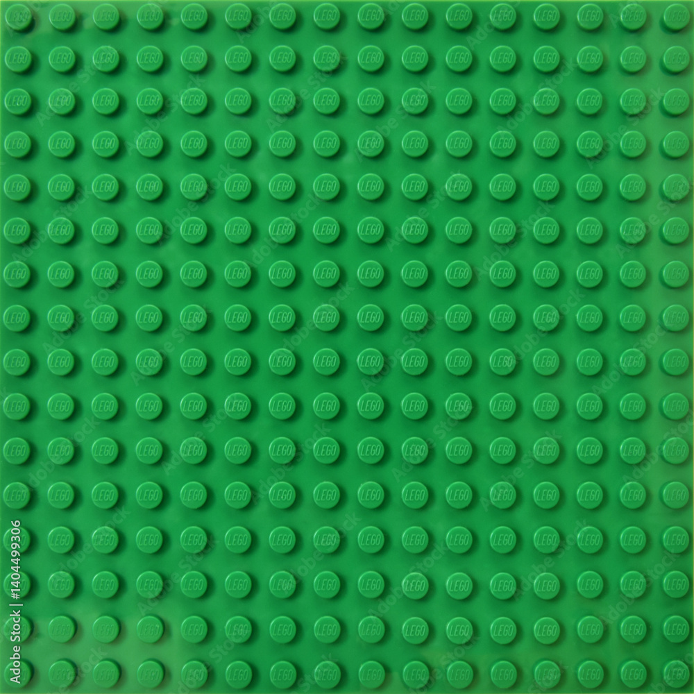 Obraz premium Lego green baseplate with rows of round knots to assembly plastic bricks from popular toy brand. Editorial illustrative image of popular children plastic toy.