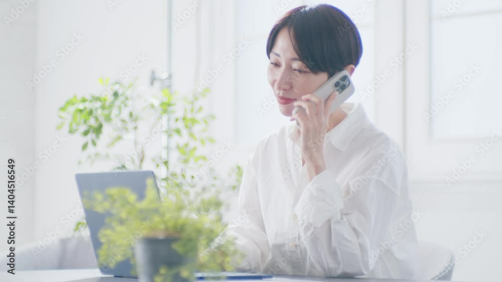 明るい部屋でオンラインミーティングする女性
