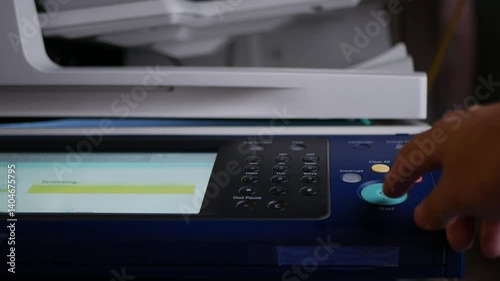 Close up hand office man press start button on panel to using the Office professional multi-function printer scanner for scanning document printing. a Copy machines