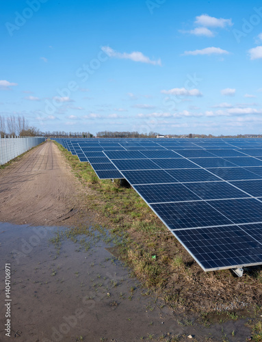 solar panel field under blue sky with fluffy clouds in dutch area near utrecht in holland