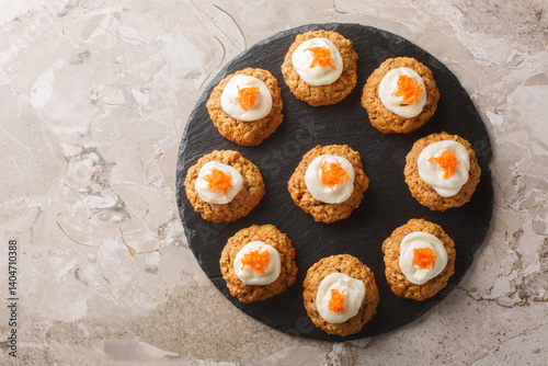 Obraz na płótnie Homemade Carrot oatmeal cookie cake with cream cheese frosting close-up on plate on table. Horizontal top view from above w salonie