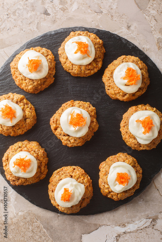 Obraz na płótnie Delicious carrot cake cookies with cream cheese frosting are a must-have Easter dessert close up on the plate on the table. Vertical top view from above w salonie