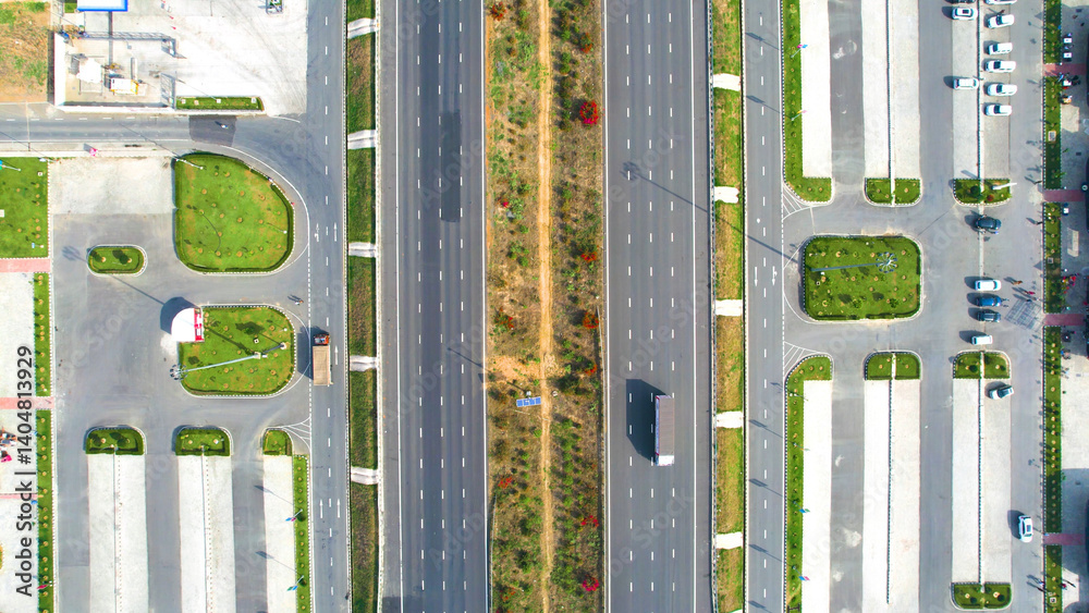 Obraz premium Aerial drone straight down show showing the new six lane delhi mumbai expressway with the rest areas on the side of the road with fuel, food outlets, parking areas and parks