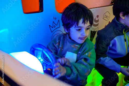 Obraz na płótnie Child driving toy car in amusement park with neon lights w salonie