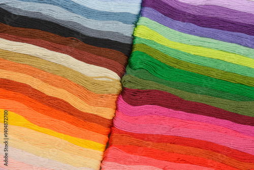 A close-up view of colorful threads arranged horizontally in warm earth and cool blue tones