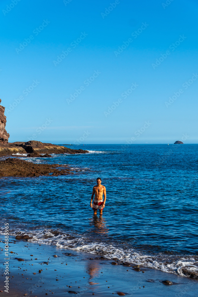 Tourist enjoying the clear water of tufia beach in gran canaria, spain