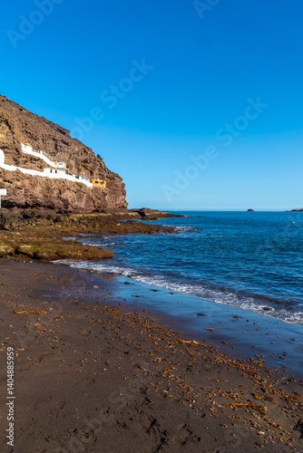 Obraz na płótnie Tufia village on gran canaria island with black sand beach and blue sea waves crashing on the shore w salonie