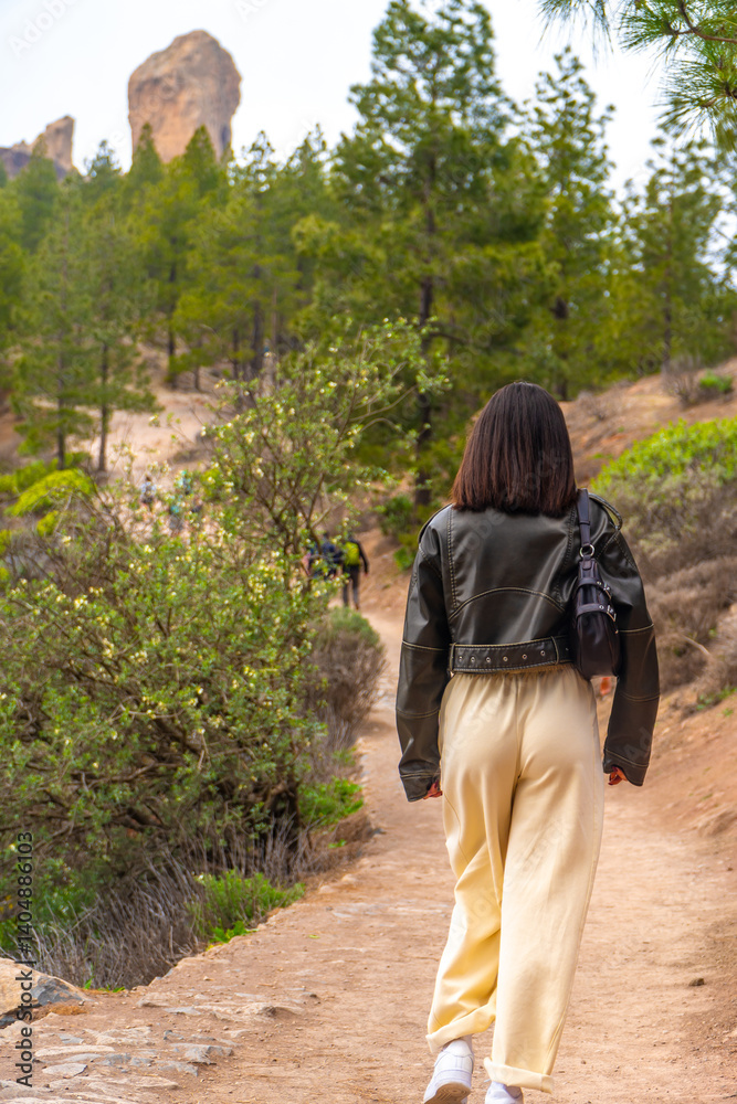 Tourist walking towards roque nublo in gran canaria, spain