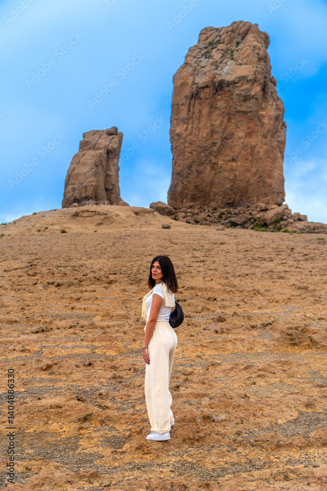Tourist hiking to roque nublo volcanic rock in gran canaria, spain