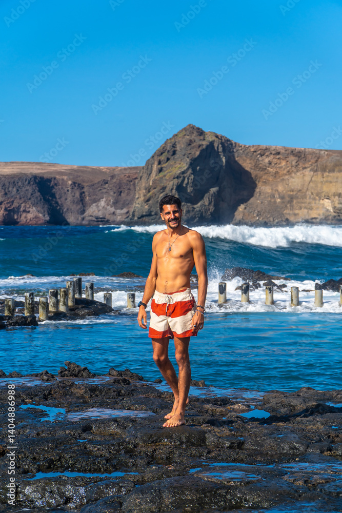 Tourist walking on volcanic rocks in agaete, gran canaria