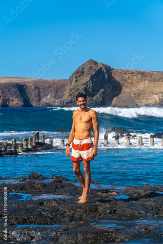 Obraz na płótnie Tourist walking on volcanic rocks in agaete, gran canaria w salonie