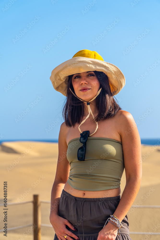 Tourist wearing sun hat exploring maspalomas dunes in gran canaria