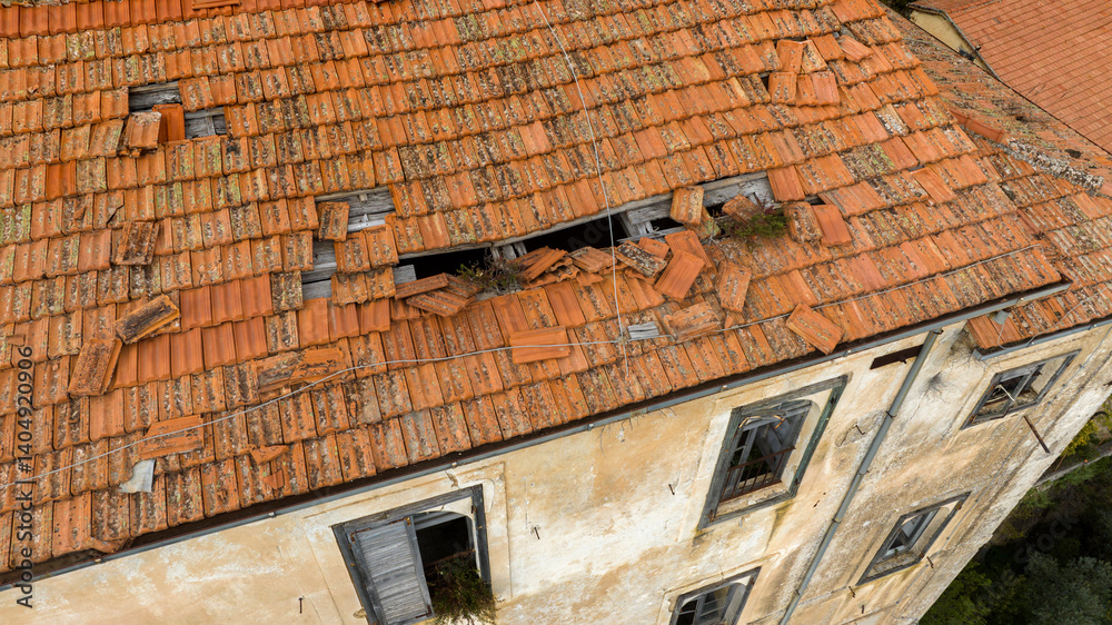 Aerial view of a broken roof with red tiles.