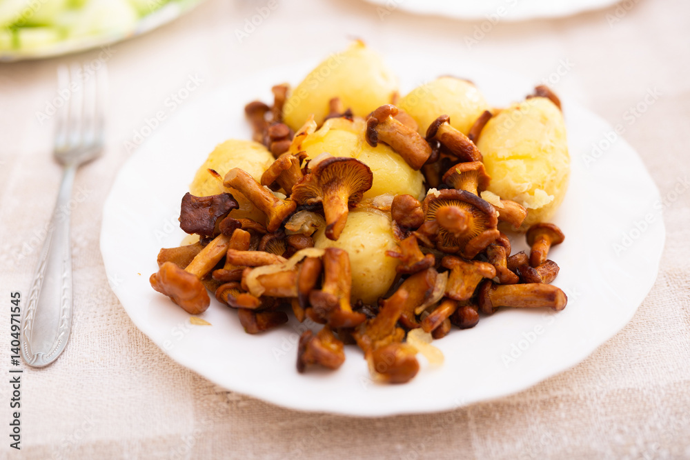 Delicious fried chanterelles with new potatoes on a white plate Delicious fried chanterelles with new potatoes on a white plate