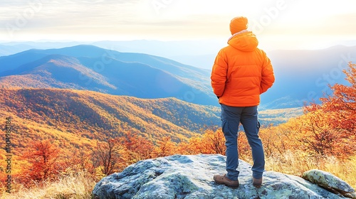 Man in orange jacket enjoys autumn mountain vista. photo