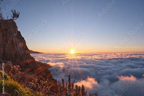 Breathtaking sunrise view over a sea of clouds in Teide National Park, Tenerife, Canary Islands. The silhouette of Mount Teide, Spain's highest volcano, rises in the background as morning light floods