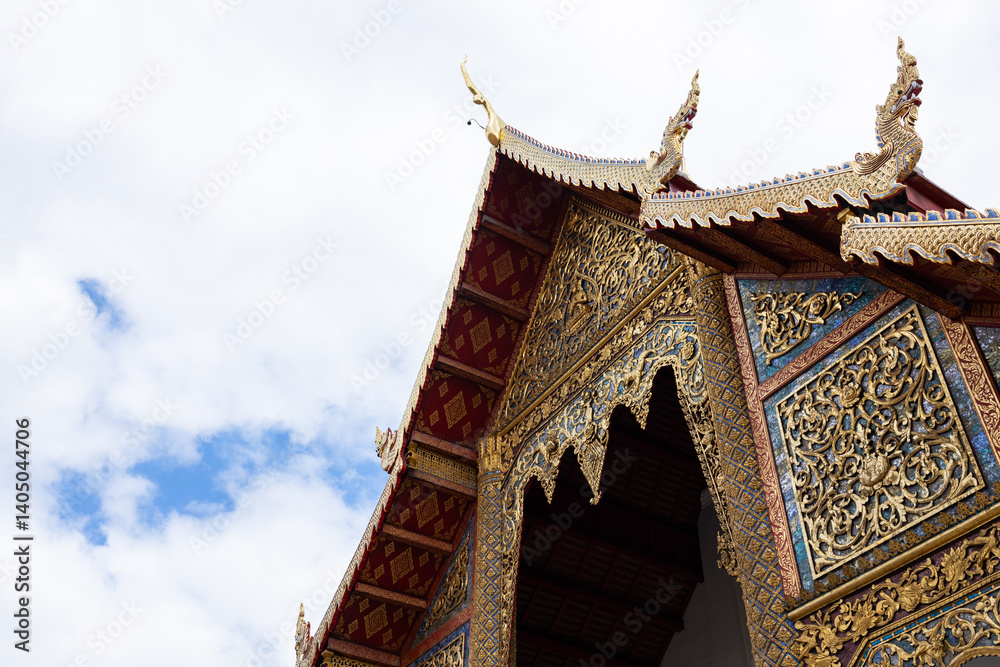 Naklejka premium Golden pagodas at Thai temple under cloudy sky